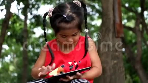 一个亚洲女孩在玩平板电脑游戏视频的预览图