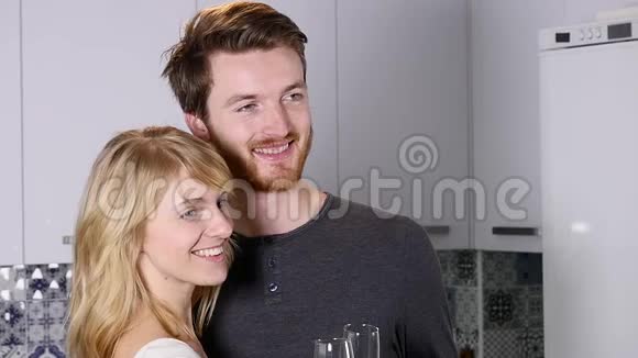 年轻夫妇在家里的厨房里喝红酒视频的预览图