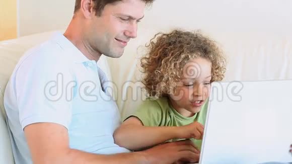 父子俩在笔记本电脑上看视频视频的预览图