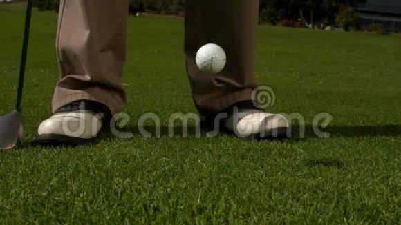 高尔夫球落在高尔夫球的脚和球杆旁边视频的预览图