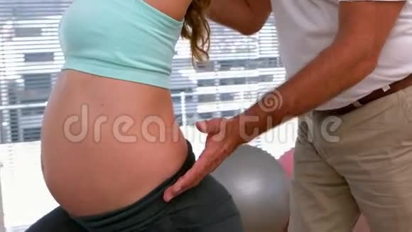 孕妇和私人教练一起做瑜伽视频的预览图