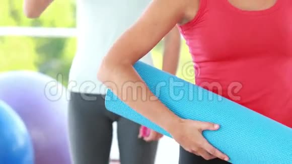 微笑运动的女人拿着瑜伽垫视频的预览图