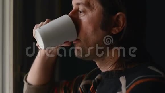 男人放松喝着一杯茶看着窗外视频的预览图