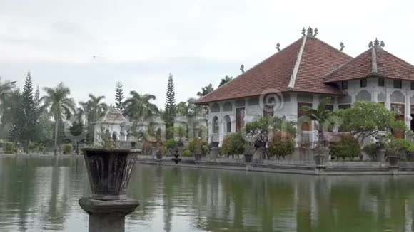 塔曼乌戎水宫位于海洋附近由美丽的热带花园装饰印度尼西亚巴厘岛视频的预览图