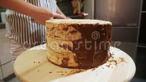 在海绵蛋糕上放上巧克力奶油的女人手的特写视频的预览图