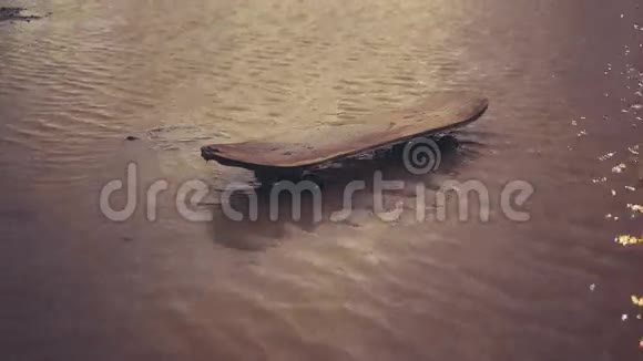 旧滑板在肮脏的水坑里视频的预览图