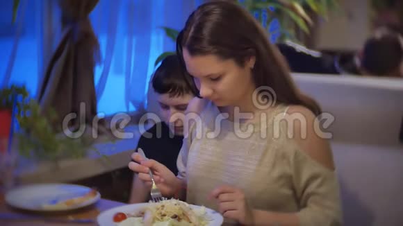 女孩在快餐店吃沙拉一群朋友坐在室内咖啡馆里视频的预览图