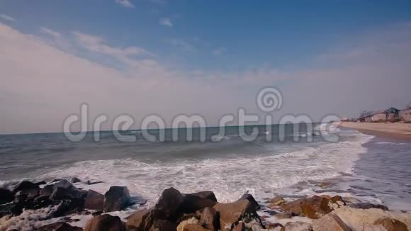 海岸上的建筑被毁海边的秋意沙滩上的波浪翻滚视频的预览图