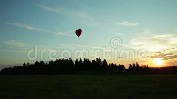 热气球飞过树木日落视频的预览图