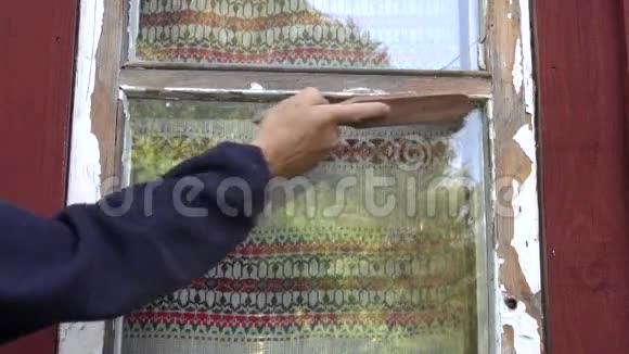 工人从房子窗户刮旧油漆视频的预览图