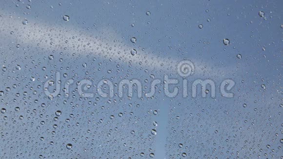 蓝天前有水滴的湿窗视频的预览图