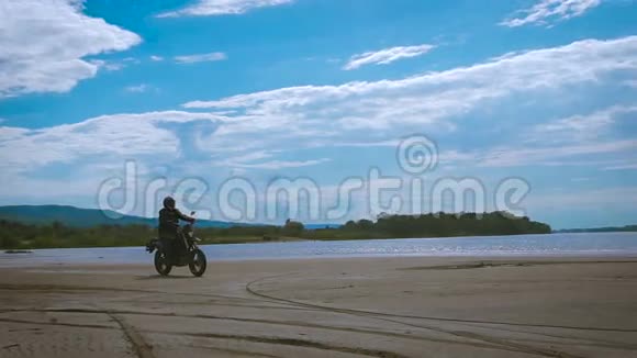 自由的感觉和莫托美学摩托车手在沙滩上骑自行车视频的预览图