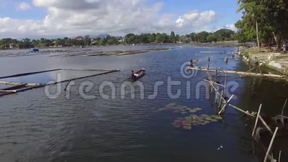 船夫在山湖上划着一艘小小的木制渔船无人机视频的预览图