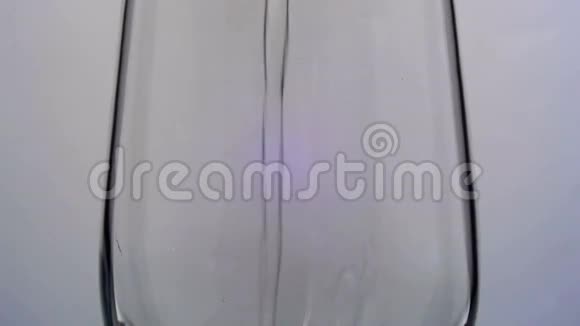 水被倒入白色背景上的透明玻璃中慢动作视频的预览图