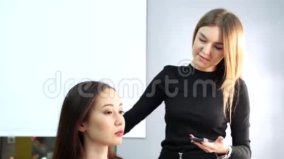 化妆师在美容工作室的模特脸上涂粉视频的预览图