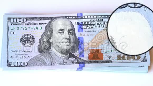 100美元新钞票上的放大玻璃视图视频的预览图