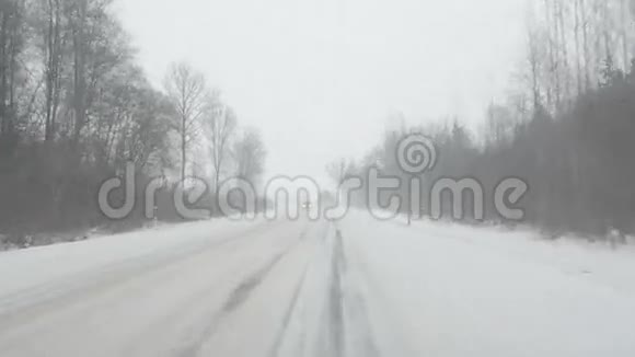 汽车在滑溜的乡间小路上冬天大雪纷飞视频的预览图