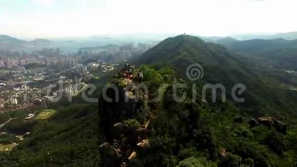 山顶上的年轻徒步旅行者坐在陡峭的悬崖上欣赏山谷景色视频的预览图