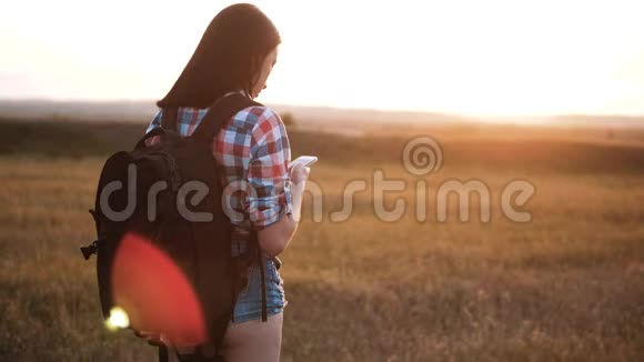 hipsterhiker的剪影女孩走着流浪的背包在手机上搜索位置导航视频的预览图