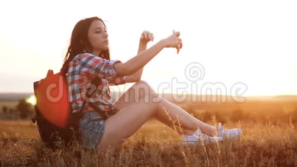 hipsterhiker剪影女孩旅行者休息慢动作视频与背包做自拍自画像旅行视频的预览图