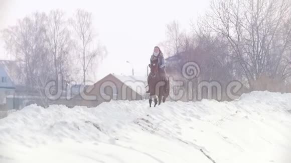 长发女骑手狂野而快速地骑着黑色的马穿过雪慢动作视频的预览图