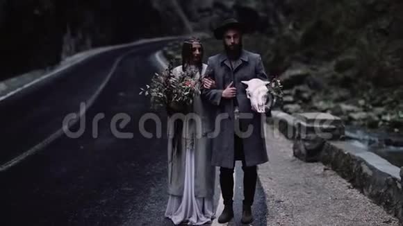 时髦的时髦情侣波赫吉普赛女人和戴帽子的男人乡村时尚的外观山脉和森林上路吧视频的预览图