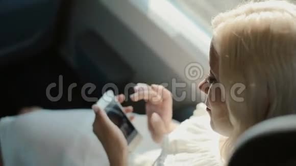 坐火车的漂亮女孩带着手机视频的预览图