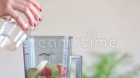 女人用手在水果搅拌机里倒水视频的预览图