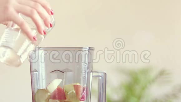 女人用手在水果搅拌机里倒水视频的预览图