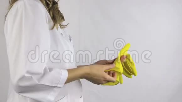 手放无菌黄色手套锻炼手部白色背景视频的预览图