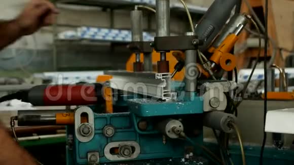 生产和制造PVC窗男性工人在PVC型材的钻床上钻孔视频的预览图