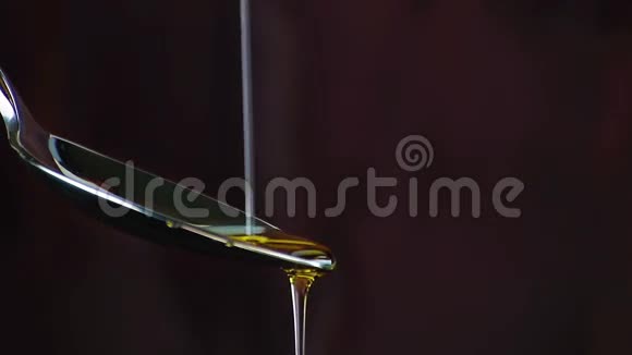 特级初榨橄榄油倒在木材背景上的勺子上视频的预览图