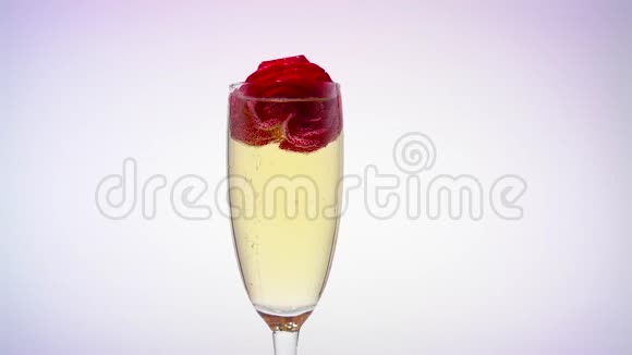 一杯带玫瑰花蕾的香槟白色背景视频的预览图