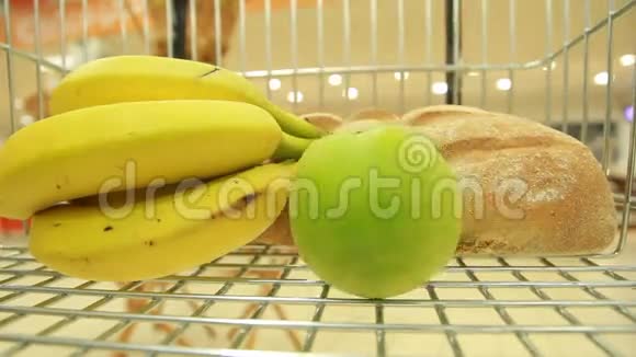 香蕉和苹果在超市的篮子里视频的预览图