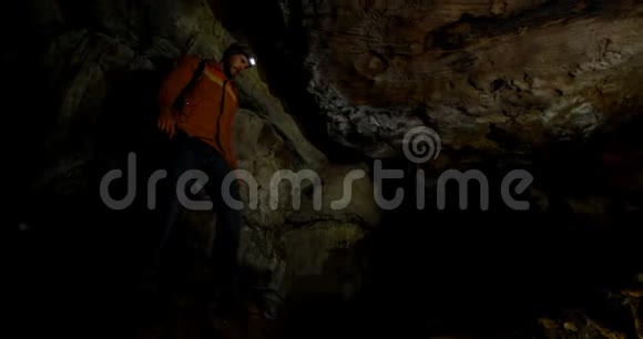 男性徒步旅行者探索黑暗洞穴4k视频的预览图