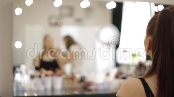 一位漂亮的女化妆师在一家大型美容院为一个红发少女化妆视频的预览图