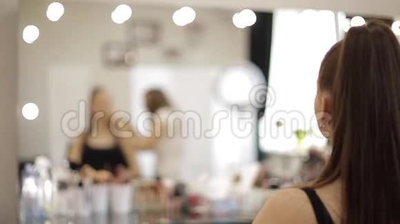 一位漂亮的女化妆师在一家大型美容院为一个红发少女化妆视频的预览图