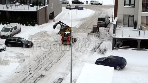 汽车通过拖拉机清洁公寓停车场冬季下雪视频的预览图