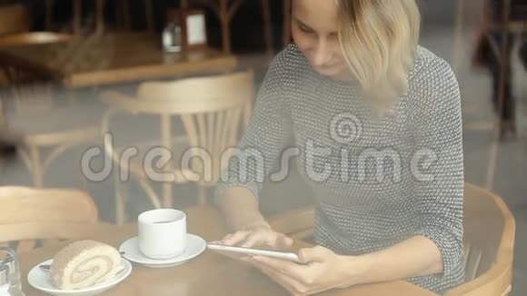 年轻漂亮的女人在咖啡馆里用药片喝茶视频的预览图