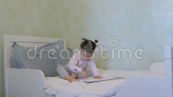 可爱的小女孩躺在床上画画视频的预览图