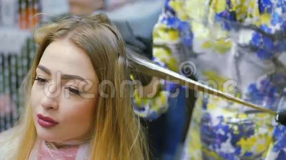 理发师染发剂金发女郎坐在美容院理发师染发视频的预览图