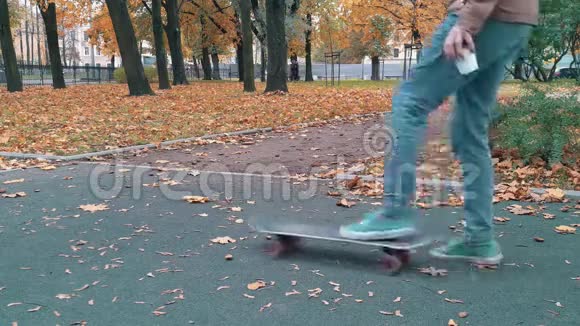 滑板手推滑板继续走秋季公园视频的预览图