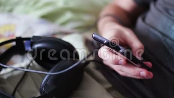 年轻人躺在沙发上拿着智能手机打印一条信息视频的预览图