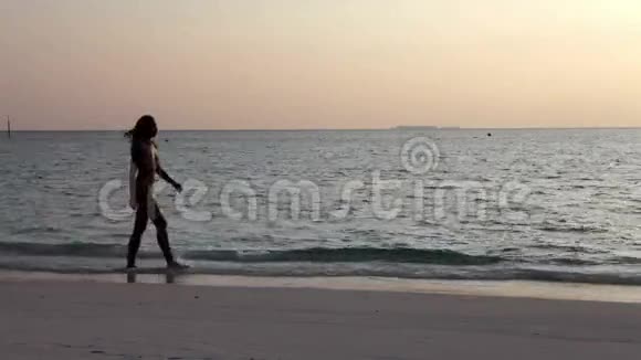 在海洋中与夕阳相映的女人剪影视频的预览图