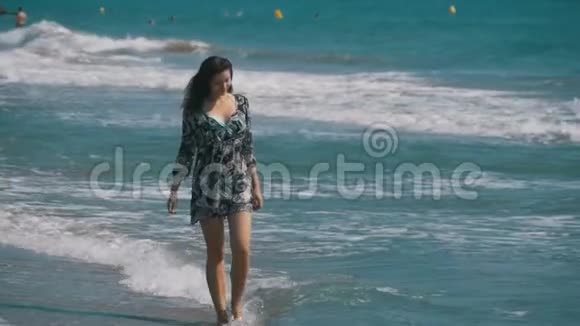 少女缓慢地沿着海岸海滩漫步视频的预览图