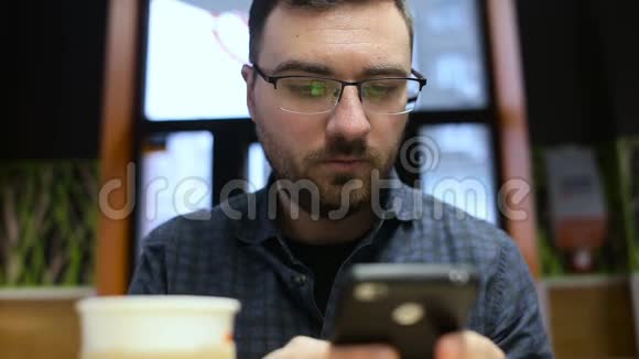 男人在咖啡馆里用手机喝咖啡视频的预览图