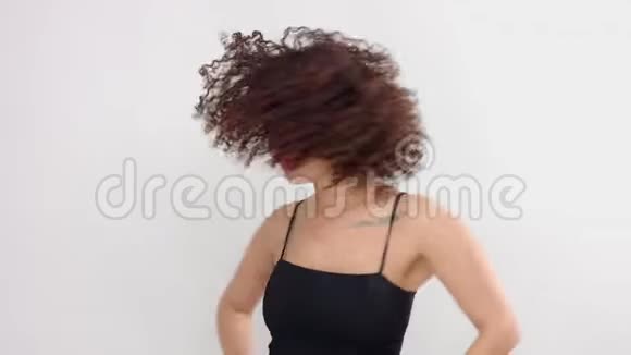 在摄影棚里一个黑人妇女她长着雀斑和卷发在镜头前摆姿势视频的预览图