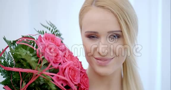 带着粉色玫瑰花束的快乐美女视频的预览图