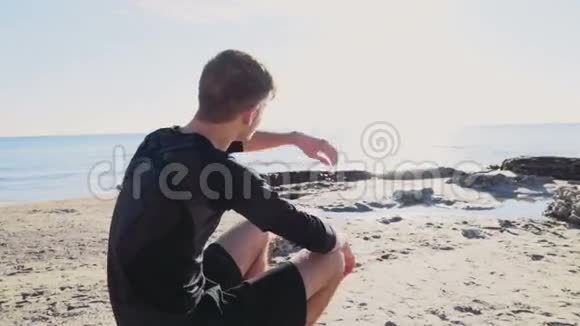 年轻运动员在海滩上享受大海和阳光的慢动作视频的预览图