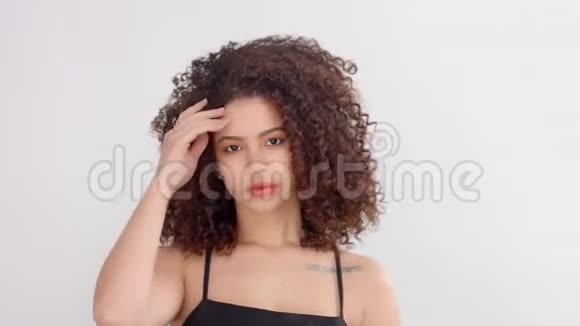 在摄影棚里一个黑人妇女她长着雀斑和卷发在镜头前摆姿势视频的预览图